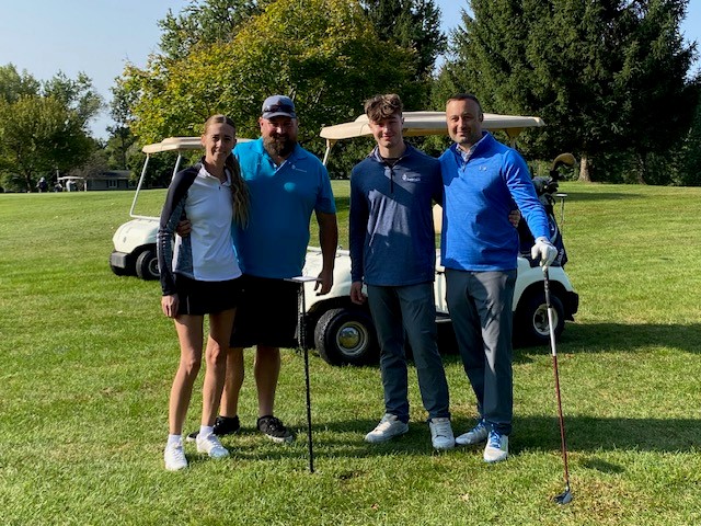 Golfers in front of a golf cart